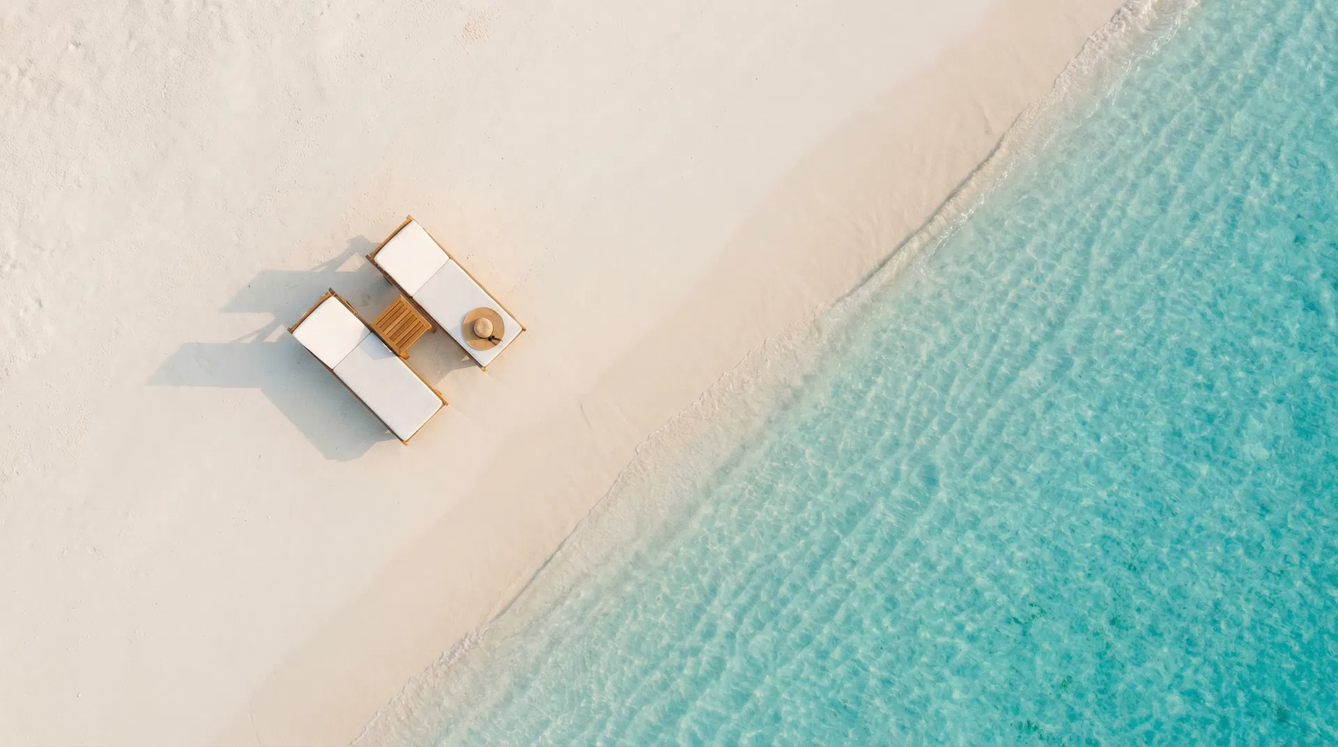 Pristine beach with luxury loungers — aerial view