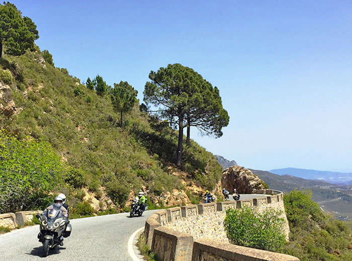 Motocykliści na trasie z widokiem na jezioro w Andaluzji