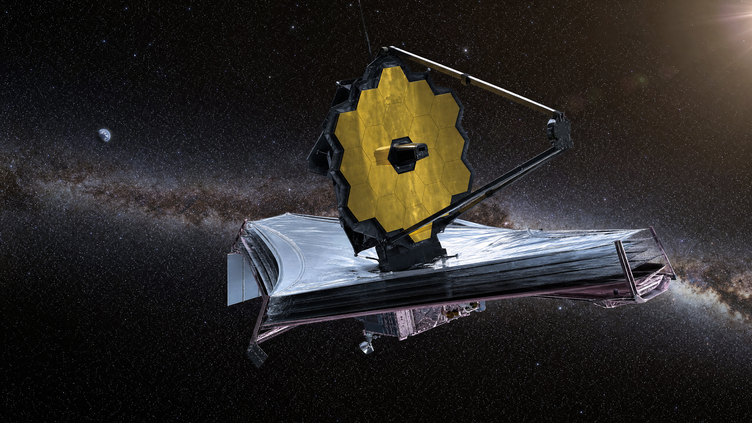 O Telescópio Espacial James Webb (JWST) em órbita no ponto Lagrangiano L2, a 1,5 milhão de quilômetros da Terra, com seu espelho primário dourado de 6,5 metros totalmente desdobrado. É a partir desse instrumento que o modo de Aperture Masking Interferometry (AMI) revelou o núcleo poeirento da galáxia Circinus.
