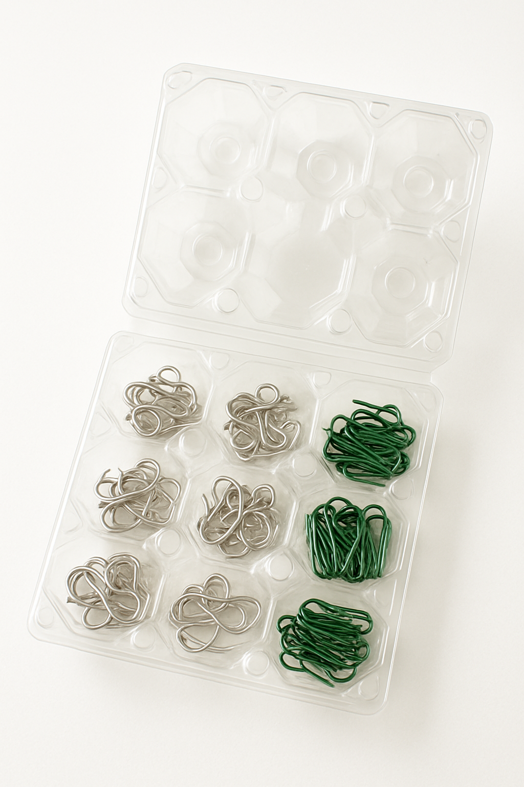 Imagem de uma caixa de ovos de plástico transparente usada para guardar pequenos ganchos e prendedores de enfeites.