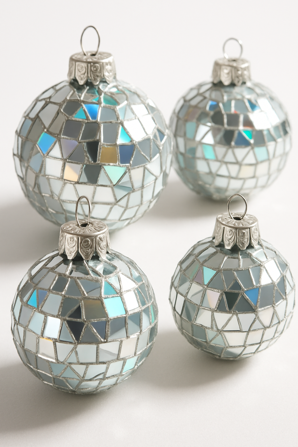 Imagem de Enfeites de bola de Natal feitos com CD's velhos quebrados e colados para criar um efeito mosaico espelhado.