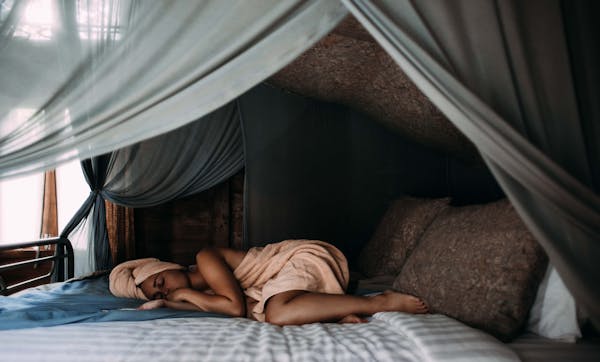 Calming image of someone resting peacefully in bed, soft lighting