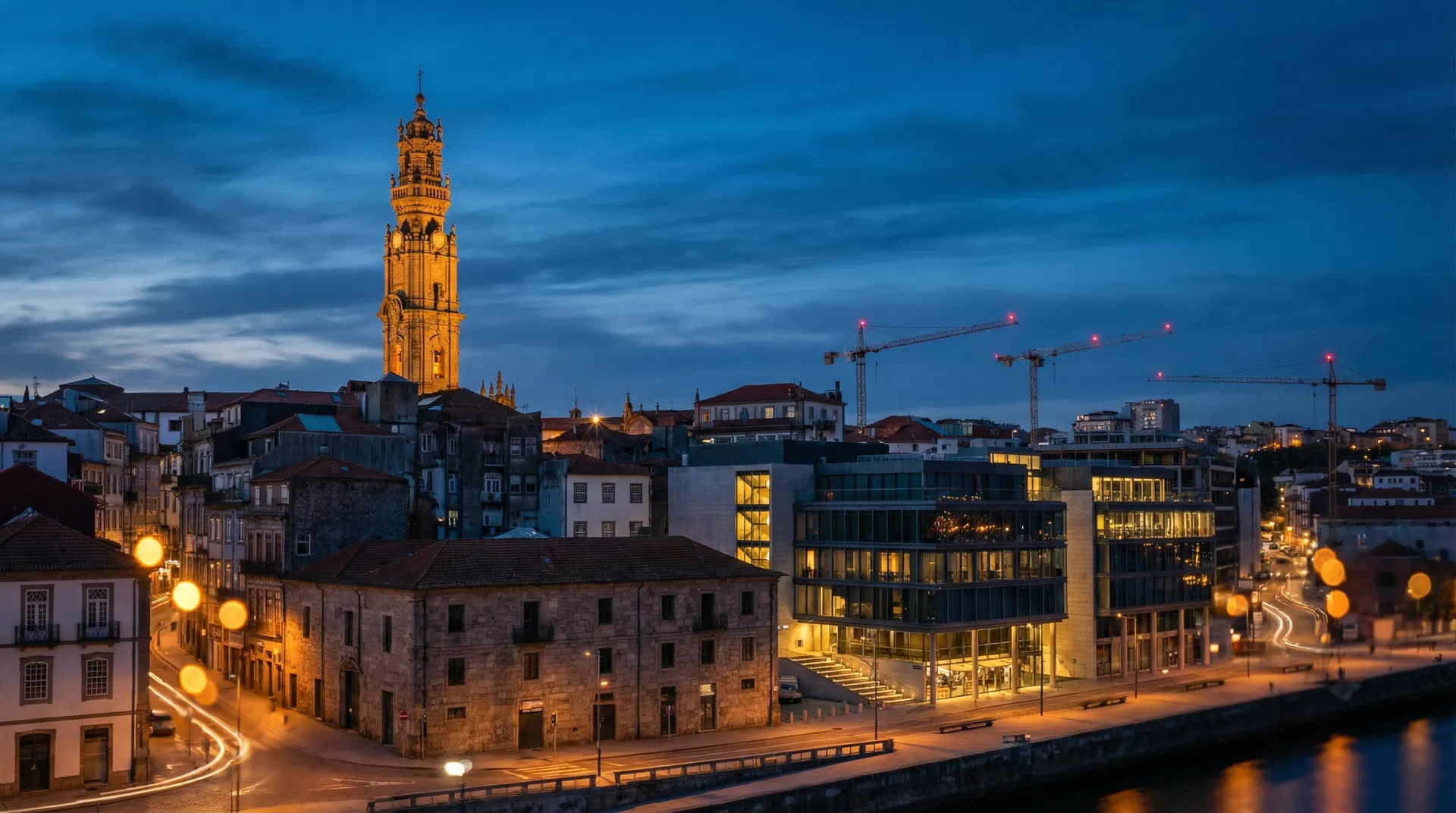 Skyline do Porto ao anoitecer com gruas de construção
