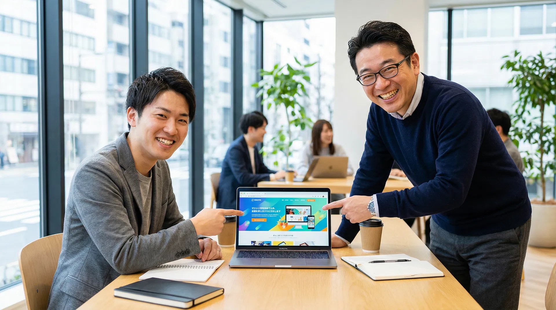 当社スタッフと飲食店オーナーが笑顔でホームページを確認している様子