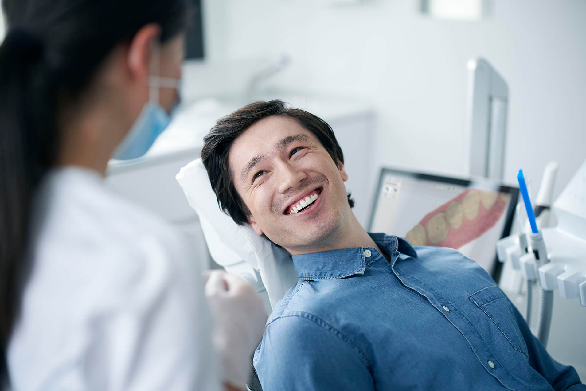 Dentista mostrando um planejamento digital do sorriso em um computador.