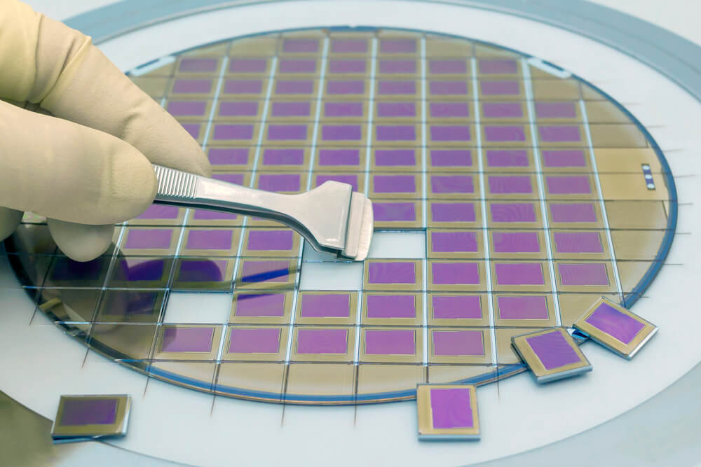 A silicon wafer showing the intricate patterns of hundreds of microchips before they are cut.
