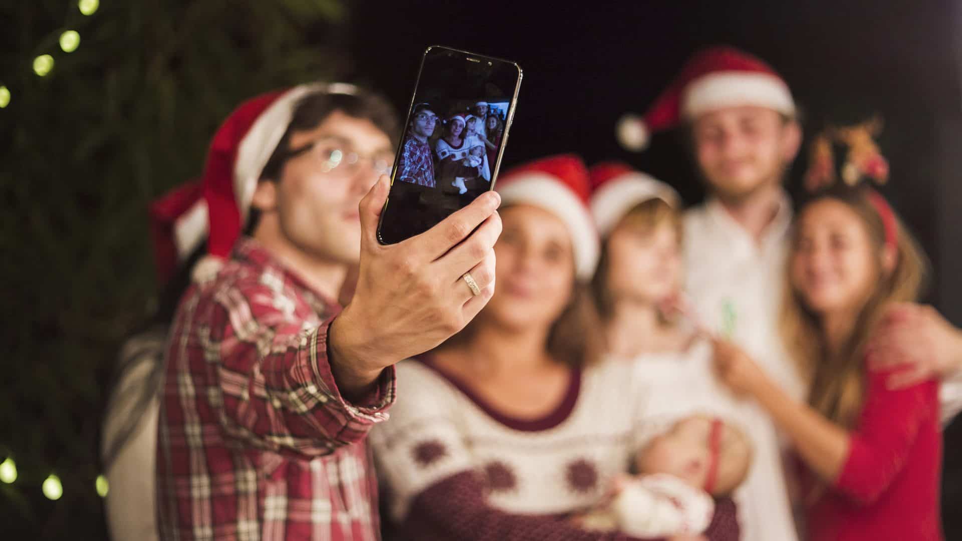 Pessoa usando a câmera do celular para fotografar um grupo de pessoas
