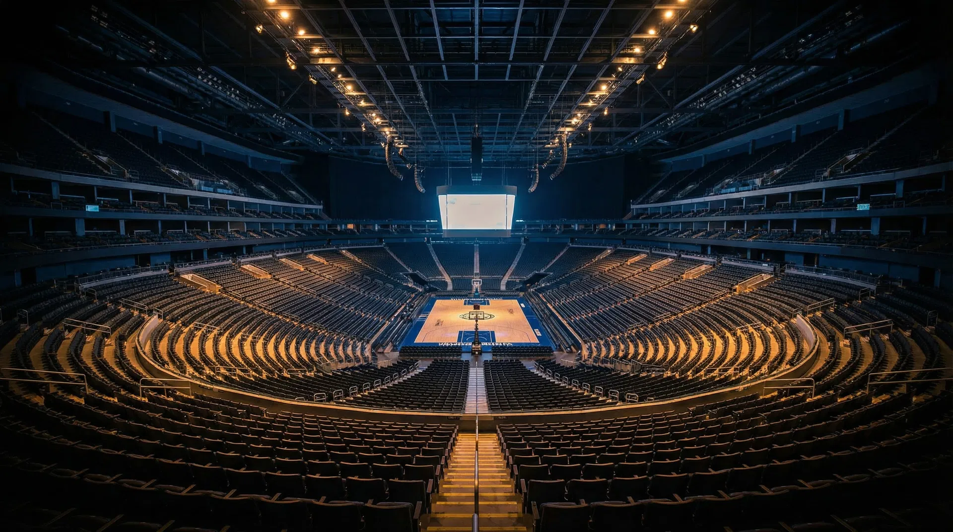 Massive empty arena with thousands of visible seating rows and basketball court — representing the scale of RRLA operations