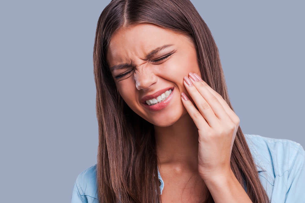 Mulher sentindo dor de dente no frio