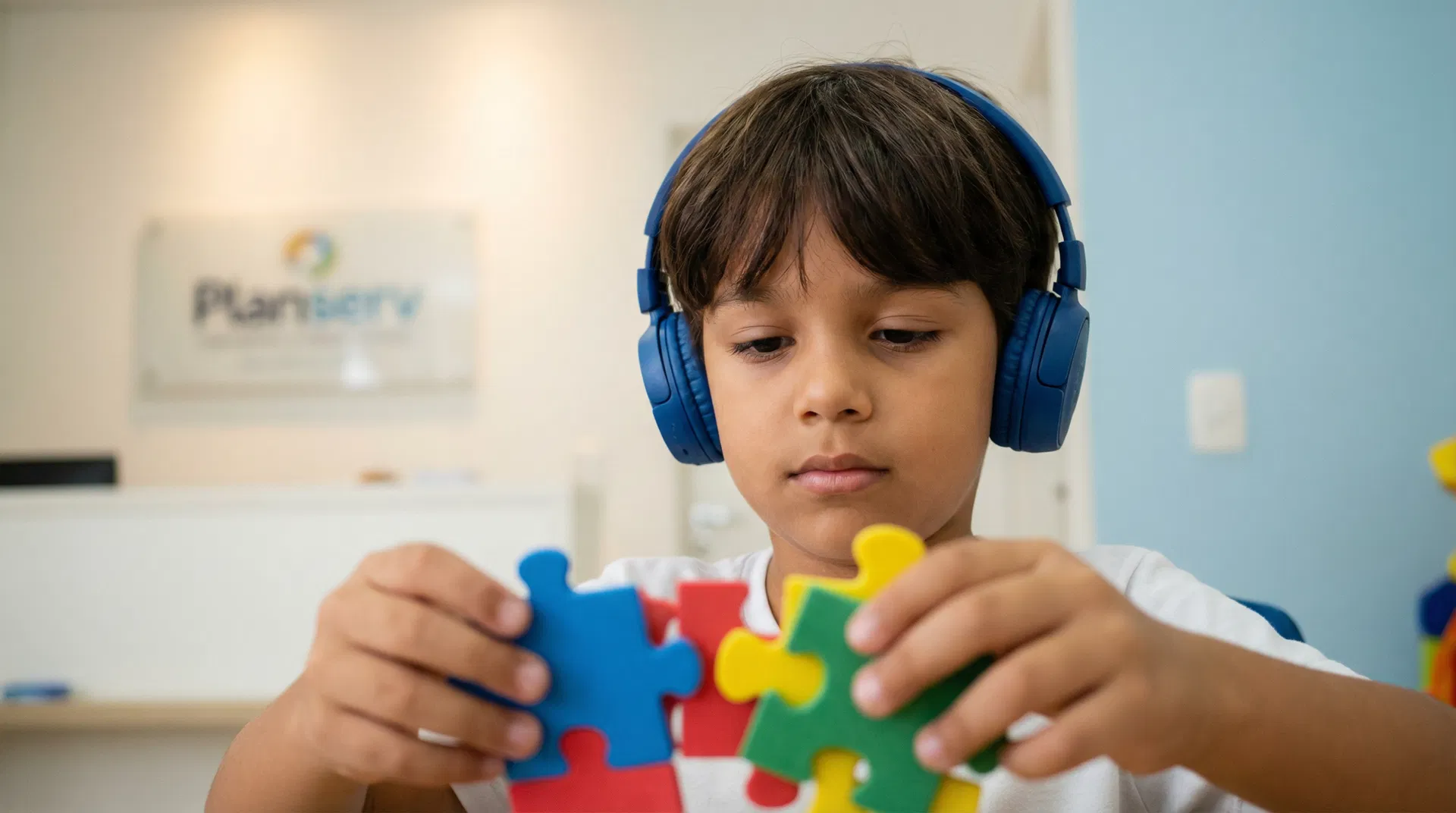 Criança autista com fone de ouvido e quebra-cabeça colorido
