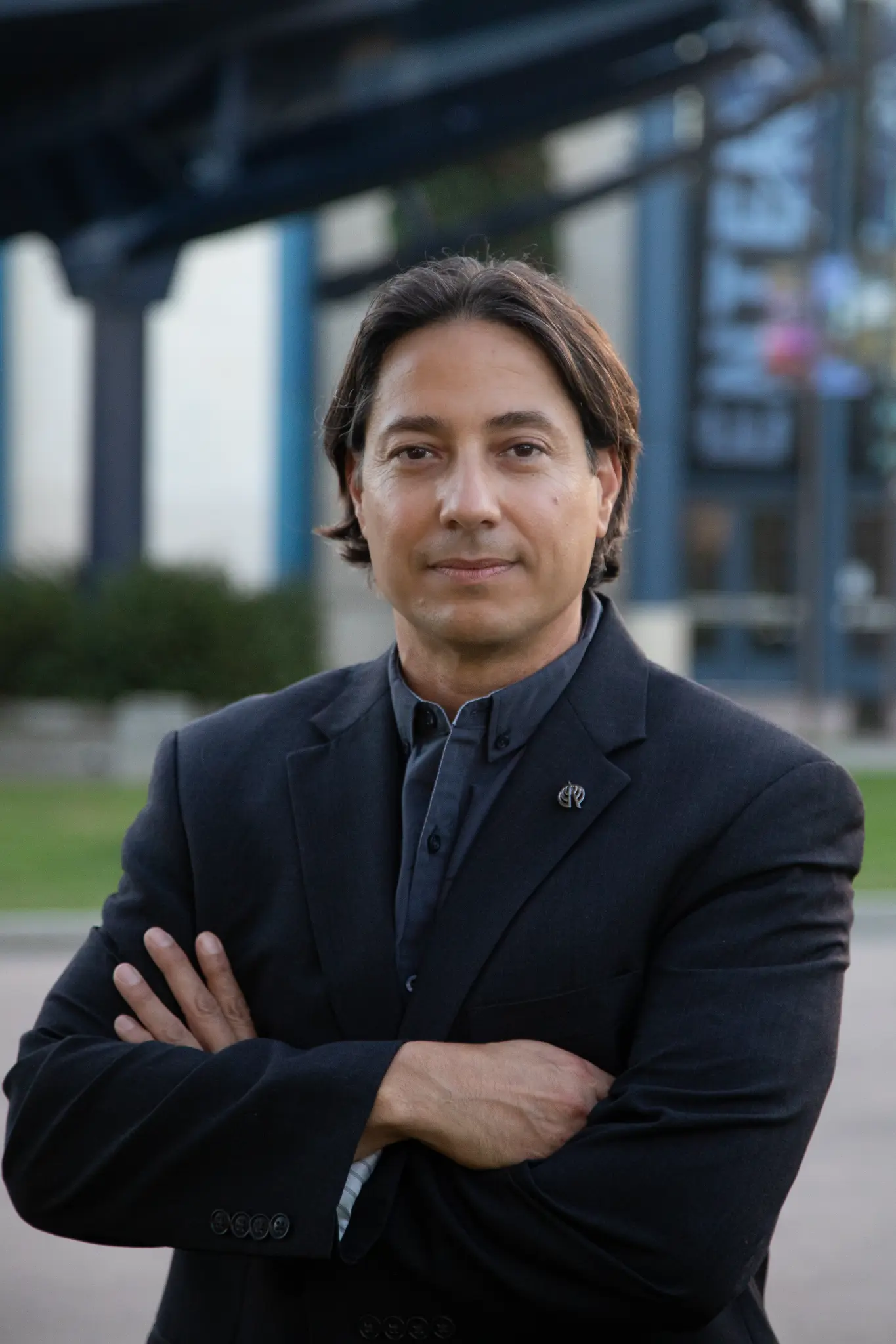 Joel L. Perez, P.E. — FAA Certified Flight Instructor and Professional Engineer, wearing a black blazer with arms crossed, photographed outdoors in San Diego