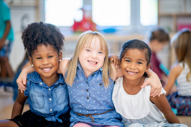 A young Black child in a wheelchair smiling joyfully at a playspace event